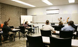 Adult Ed - Hands Raised Stock Photo