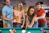 Young man teaching a young woman to play pool Stock Images