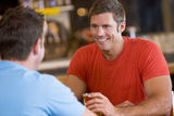 Two men talking over beer in a bar Royalty Free Stock Images