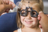 Optometrist in exam room with young girl Royalty Free Stock Photography