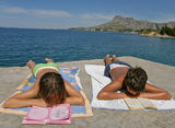 Boy and girl read at beach Stock Image