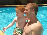 Redheaded father and son in pool Royalty Free Stock Photo