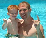 Redheaded father and son in pool Royalty Free Stock Photography