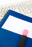 Blue school textbook and computer keyboard Royalty Free Stock Photos