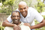 Senior Man Hugging Adult Son Stock Image
