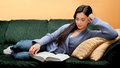 Young Woman Lying Down on Sofa and Reading Book Stock Photography