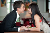 Couple Kiss Over Meal Stock Images