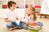 School boy showing her little sister how to read Royalty Free Stock Photos
