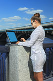 Woman with laptop on quay Stock Images