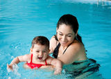 Mother teaching baby swimming Stock Photo