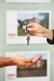 Close Up Of Estate Handing Over Keys Of New Home Stock Photo