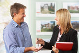 Female Estate Handing Over Keys Of New Home Stock Image