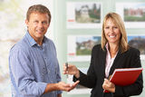 Female Estate Handing Over Keys Of New Home Royalty Free Stock Images