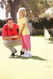Father Teaching Daughter To Play Golf Royalty Free Stock Photos