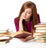 Young girl is lying on a floor and reading book Stock Photo