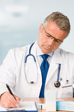 Mature doctor prescribes medical exam Stock Photo