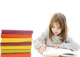 Young girl sitting at the desk and reading book Royalty Free Stock Image