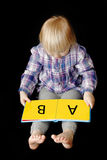 Baby girl learning to read Stock Photo