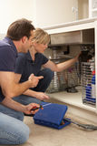 Plumber Teaching Apprentice To Fix Kitchen Sink Royalty Free Stock Image
