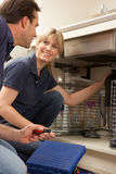 Plumber Teaching Apprentice To Fix Kitchen Sink Royalty Free Stock Image