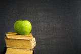 Green apple on textbook Stock Images