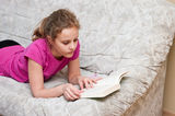 Girl reading on sofa Stock Image