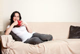 Woman with drink on couch Stock Images