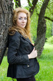 Redheaded woman near tree Stock Image
