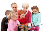 Grandparents reading kids story book to children Stock Image