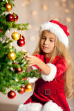 Miss santa decorating the christmas tree Stock Photos
