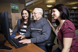 Volunteers teaching a senior how to use a computer Stock Photography