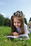 Girl read book on grass Stock Photos