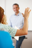 Student with hand up in class Stock Photography