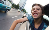 Male teenager in car enjoying city view Royalty Free Stock Image