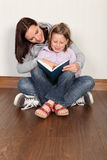 Mother teaching daughter to read home education Royalty Free Stock Photo