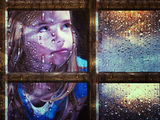 Girl at window in rain Stock Image