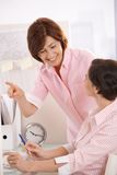 Senior office worker teaching coworker in office Royalty Free Stock Photo