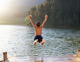 Young boy leaping into lake Royalty Free Stock Images