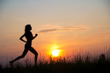 Woman running at sunset Stock Photos