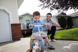 Father teaching Son To Ride a Tricycle Royalty Free Stock Photography