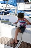 Girl reading on yacht Stock Images