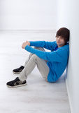 Teenager boy sitting by the wall Stock Photos