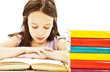Young girl sitting at the desk and reading book Stock Images