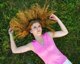Young redheaded woman lying on the grass Royalty Free Stock Photography