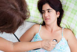 Sick hispanic woman having a heart examination Royalty Free Stock Photos