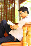 Young Asian Student Sitting and Reading Textbook Royalty Free Stock Image
