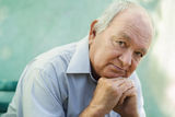 Portrait of sad bald senior man looking at camera Stock Photo