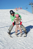 Father Teaching Daughter To Ski Whilst On Holiday Stock Image