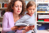 Daughter with mother read book in room Royalty Free Stock Photography