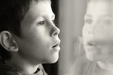 Young boy in thought with window reflection Royalty Free Stock Photo